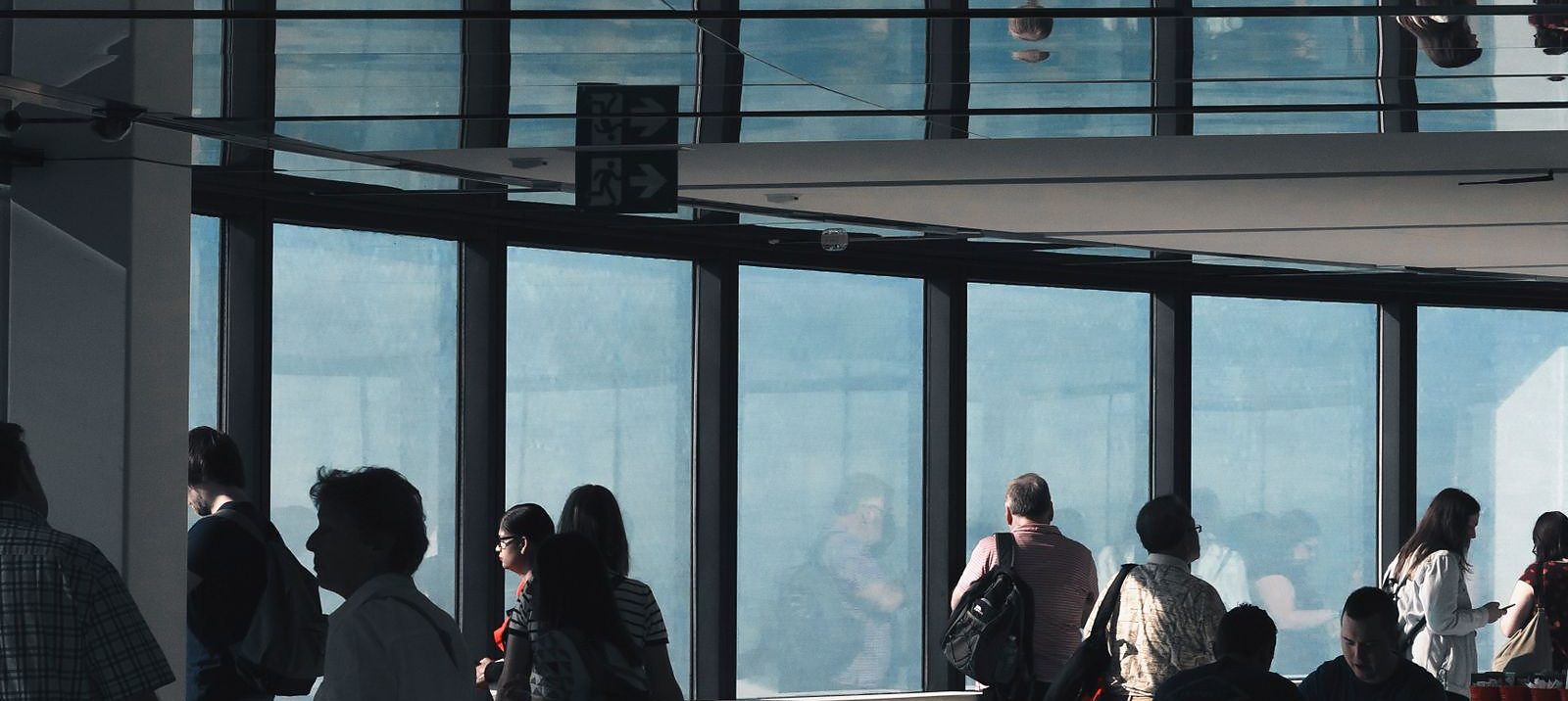 Una fila di persone dentro un edificio pubblico vetrato